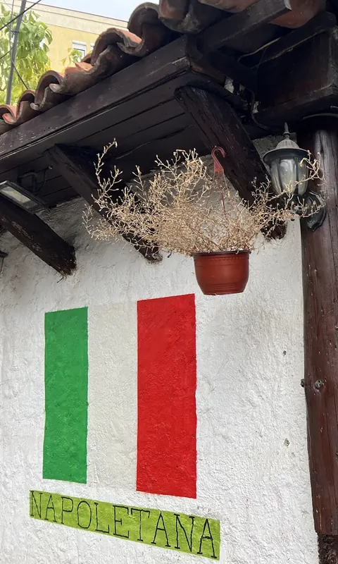 The entrance with a painted Italian flag and a NAPOLETANA sign