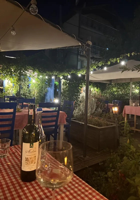 A bottle of wine on the terrace at night, under string lights
